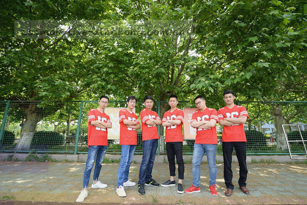 夜间室内多名工作人员在多屏数据界面前值守，桌面映出赛程表格的纹理剪影